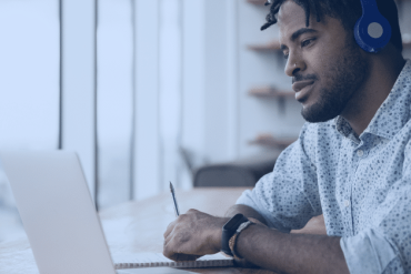 Homem experiente guiando profissional jovem em sala de reuniões moderna, representando mentoria de carreira.