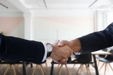 Mulher sorrindo, segurando um tablet com gráficos de recursos humanos, ambiente de escritório moderno