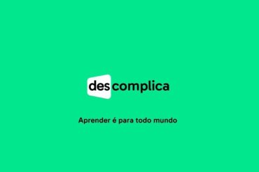 Estudante sorridente acessando o curso Descomplica Exatas em um laptop moderno